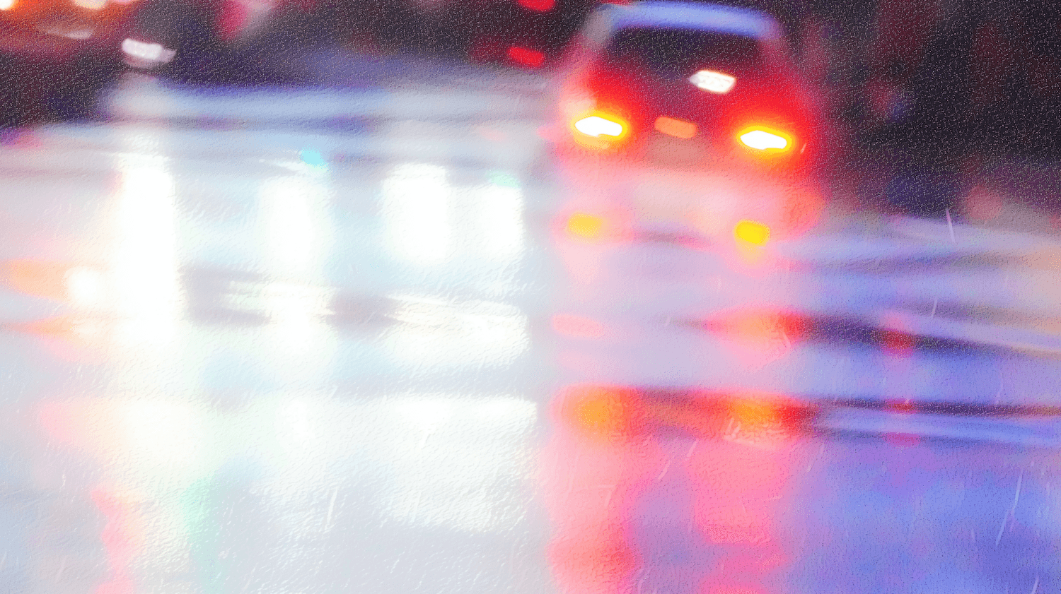 Car tail lights blurred by rain on a wet street at night